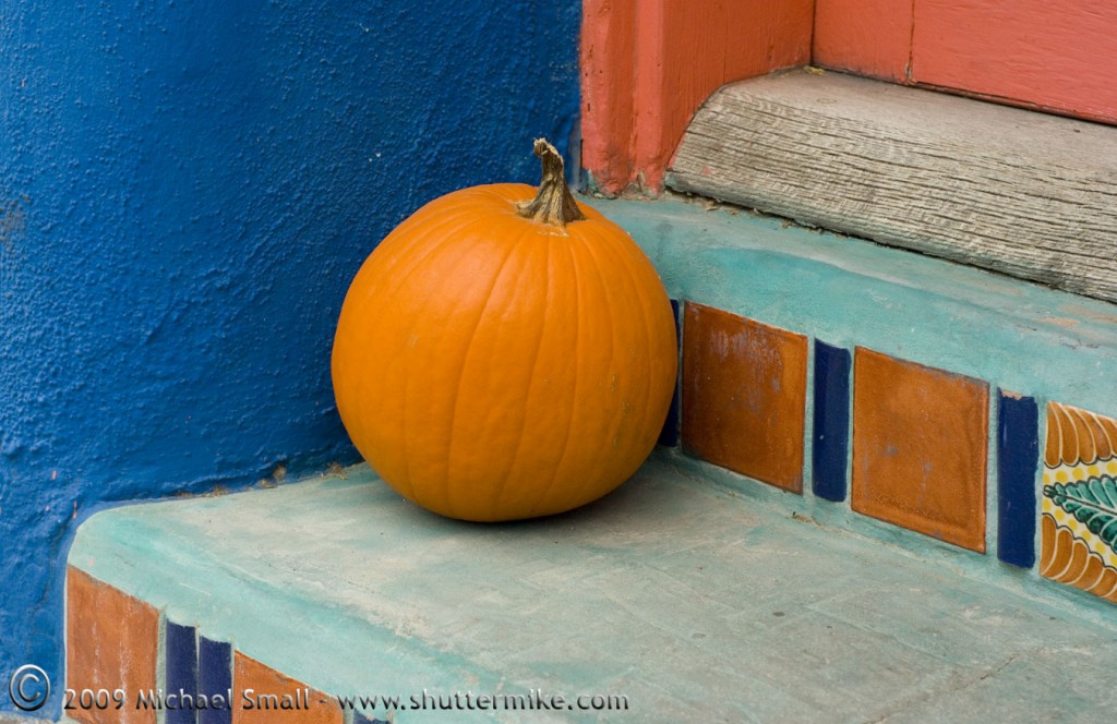 Photo of a pumpkin on a colorful doorstep