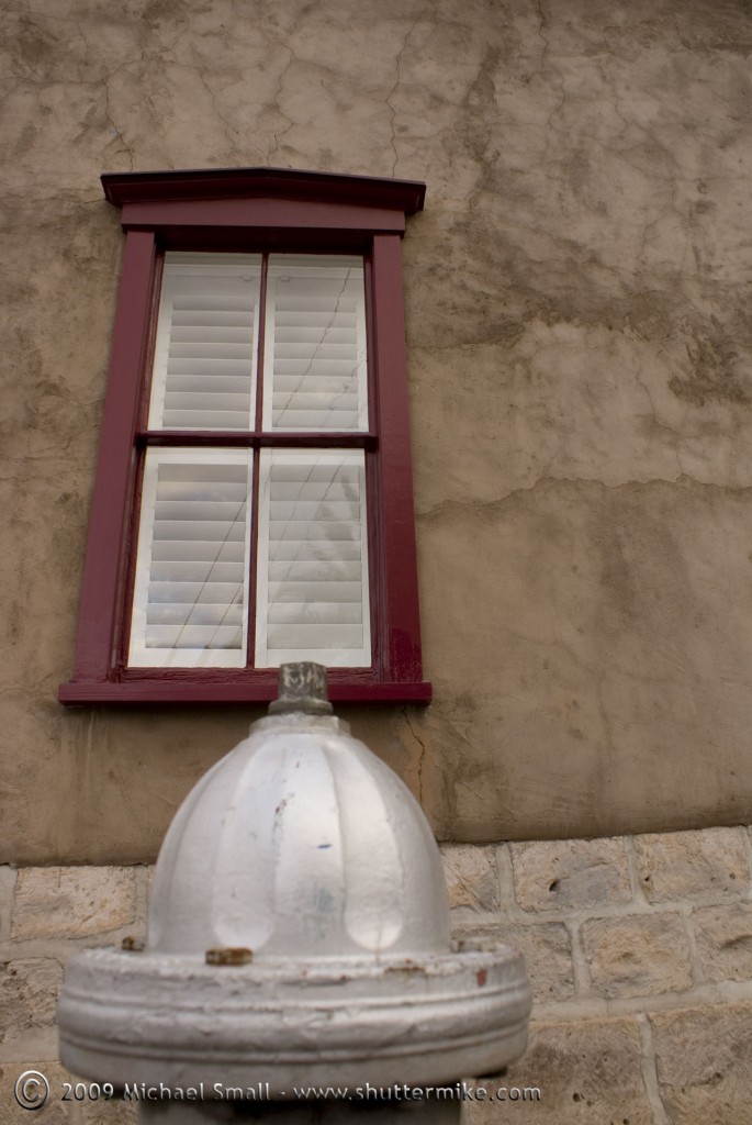Photo of a silver fire hydrant and red window