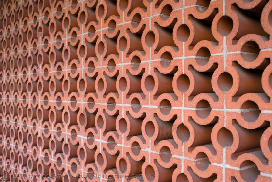 Photo of a wall made from red circular bricks.
