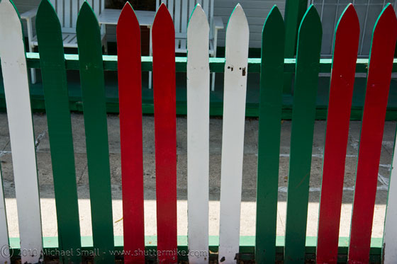 Photo of a red, white and Green picket fence