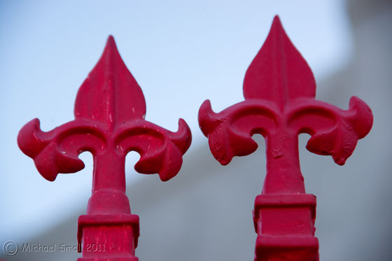 Photo of two red wrought iron fence finials