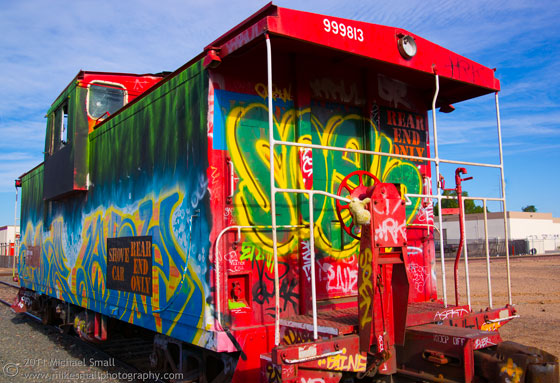 Photo of a graffiti sprayed red caboose